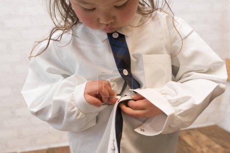 Photo for Cute little girl putting on shirt - Royalty Free Image