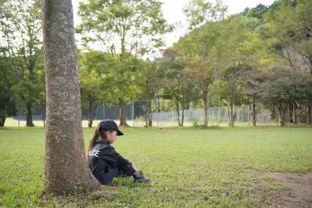 Téléchargez les photos : Petite fille portant un costume de police assis dans le parc - en image libre de droit