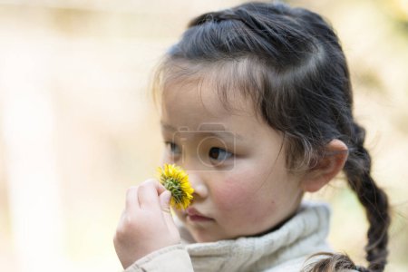 Photo for Little asian girl with flower  in the park - Royalty Free Image