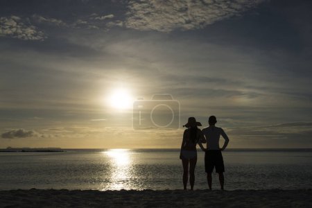 Téléchargez les photos : Silhouettes homme et femme à la plage du coucher du soleil - en image libre de droit