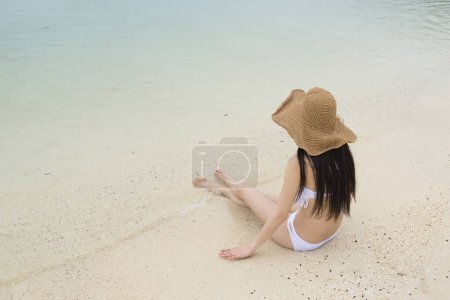 Photo for Woman in swimsuit sitting on the beach - Royalty Free Image