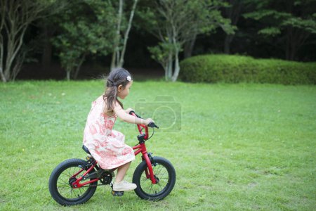 Photo for Little girl riding bicycle in park. - Royalty Free Image