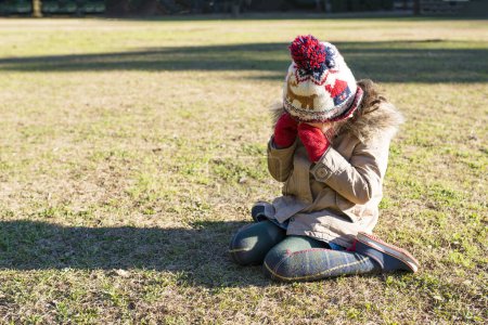 Téléchargez les photos : Mignon asiatique gitl assis dans un parc - en image libre de droit