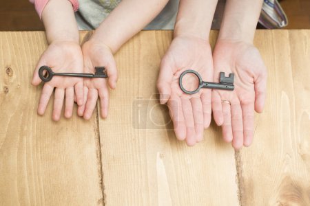 Photo for Parent and child hands with a keys - Royalty Free Image