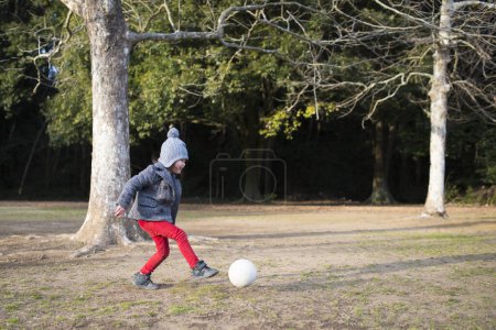 Téléchargez les photos : Une fille jouant avec le ballon de football sur le terrain - en image libre de droit