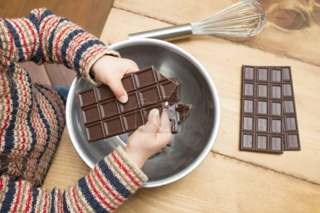 Téléchargez les photos : Mère et fille cassant chocolat - en image libre de droit