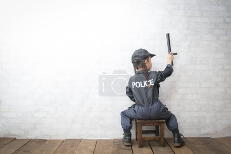 Téléchargez les photos : Arrière d'une fille en costume de police - en image libre de droit