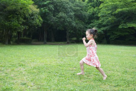 Photo for Asian girl playing in the park - Royalty Free Image