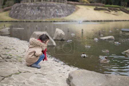 Girl playing on the side of the pond