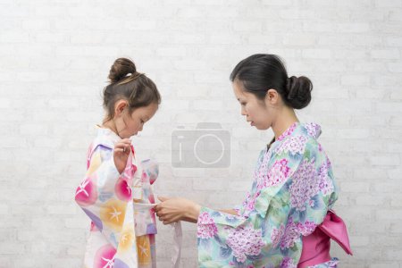 Foto de Madre e hija al aderezo de yukata - Imagen libre de derechos