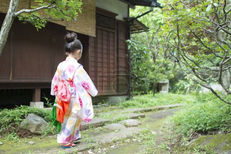 Téléchargez les photos : Mignonne petite fille asiatique avec un kimono japonais traditionnel dans le parc - en image libre de droit