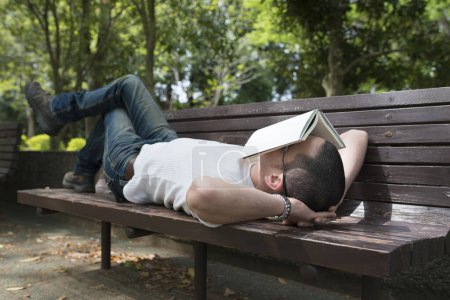 Foto de El hombre que toma una siesta en un banco del parque - Imagen libre de derechos