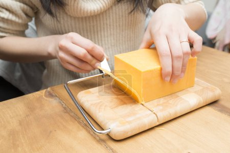Téléchargez les photos : Femme qui a coupé le fromage - en image libre de droit
