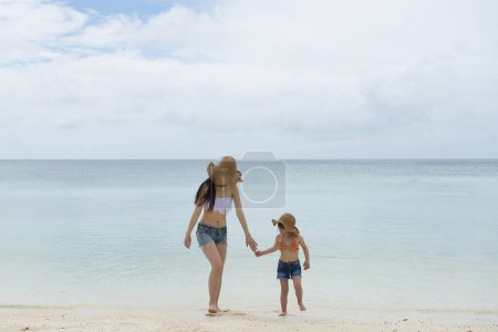 Téléchargez les photos : Mère et fille jouant sur la plage - en image libre de droit