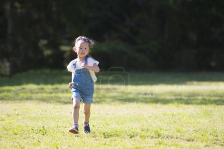 Téléchargez les photos : Fille courir sur la pelouse dans le parc - en image libre de droit