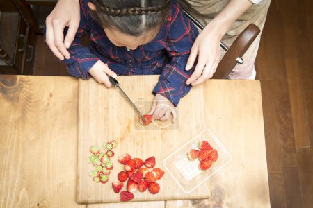 Girl cutting strawberries on board