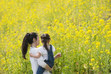 Photo for Mother and daughter playing in the rape field - Royalty Free Image