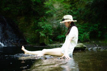 Une femme se relaxant dans un ruisseau de montagne