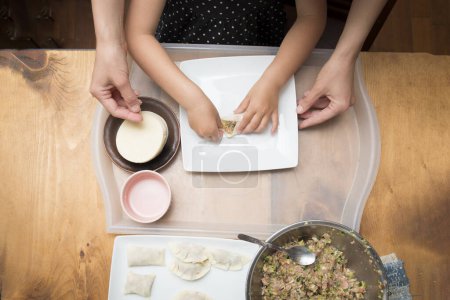 Photo for Mother and daughter making dumplings - Royalty Free Image