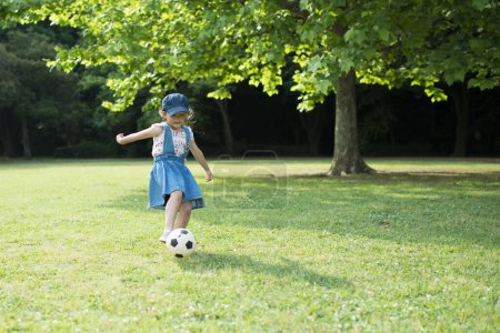 Photo for Little girl playing  with football ball in park - Royalty Free Image