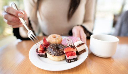 Photo for A woman who eats a lot of sweets - Royalty Free Image