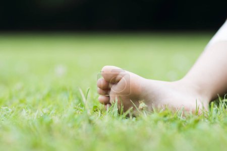 Téléchargez les photos : Pied d'enfant sur herbe verte - en image libre de droit