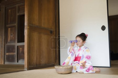 Téléchargez les photos : Petite fille regardant le kaléidoscope avec une silhouette de yukata - en image libre de droit