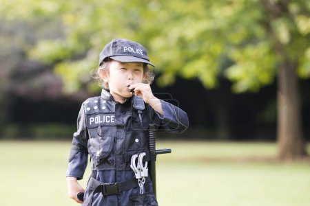 Téléchargez les photos : Petite fille siffler en costume de police - en image libre de droit