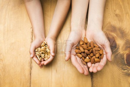 Photo for Child with walnuts and mother with almonds - Royalty Free Image