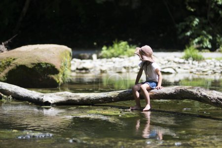 Téléchargez les photos : Petite fille par rivière dans la forêt - en image libre de droit