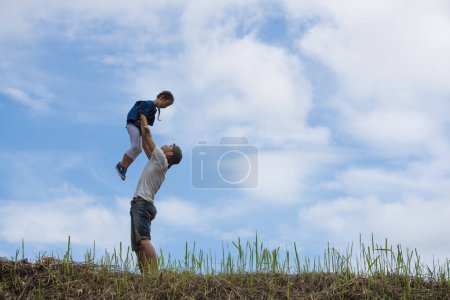 Téléchargez les photos : Père et fille jouent dans la prairie - en image libre de droit
