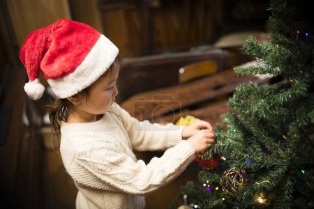 Téléchargez les photos : Jolie fille décorant le sapin de Noël - en image libre de droit