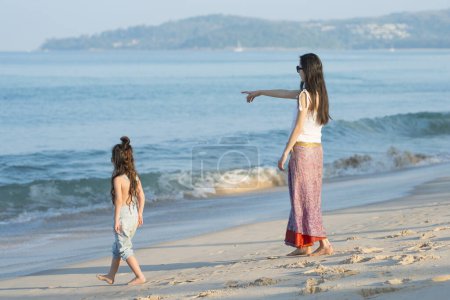 Photo for Mother and daughter walking on the beach - Royalty Free Image