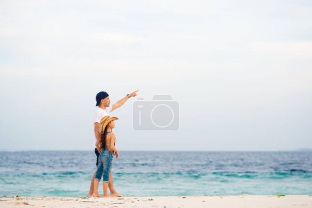 Photo for Father and daughter pointing far away on beach - Royalty Free Image