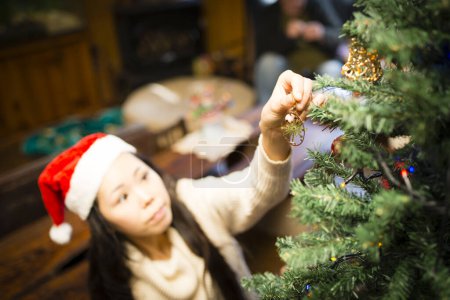 Téléchargez les photos : Une femme décorant un sapin de Noël - en image libre de droit