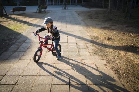 Photo for Child riding a bicycle in the park - Royalty Free Image