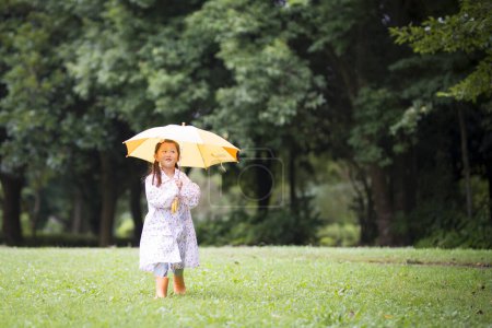 Foto de Chica caminando en parque bajo la lluvia - Imagen libre de derechos
