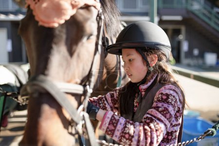 Foto de Chica preparándose para montar a caballo - Imagen libre de derechos