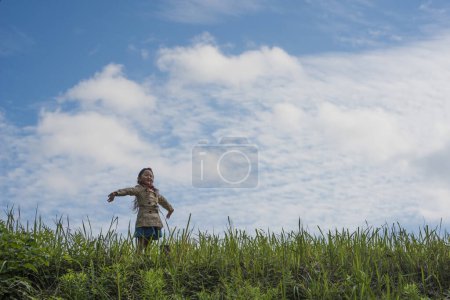 Téléchargez les photos : Petite fille jouant sur la prairie - en image libre de droit