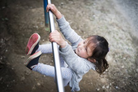 Téléchargez les photos : Petite fille jouer sur aire de jeux - en image libre de droit
