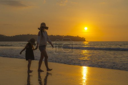 Photo for Mother and daughter playing at the sunset beach - Royalty Free Image