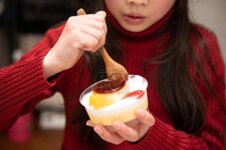 A girl eating a cute pudding