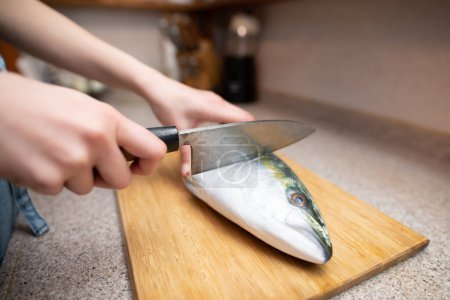 Photo for Female cooking raw fish in the kitchen - Royalty Free Image