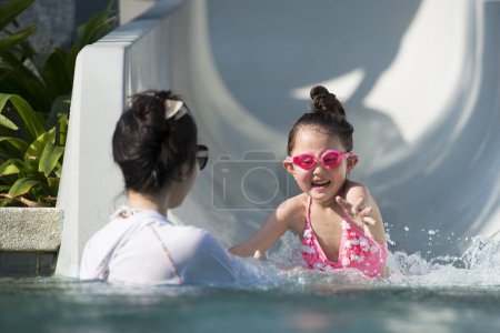 Photo for Mother and daughter playing with a water slider - Royalty Free Image