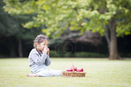 Photo for Little girl eating an apple - Royalty Free Image
