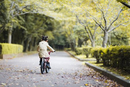 Photo for Little girl riding a red bicycle - Royalty Free Image