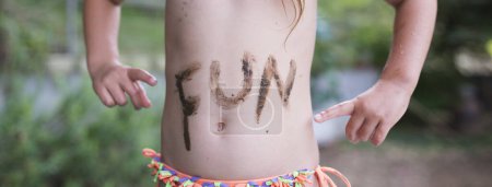 Child wrote the FUN in the mud in the stomach