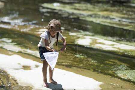 Téléchargez les photos : Bonne petite fille jouant dans la rivière - en image libre de droit