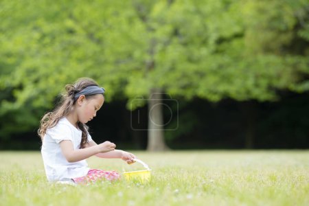 Photo for Happy little girl picking flowers - Royalty Free Image