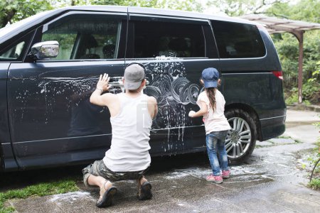 Photo for Father and daughter washing the car - Royalty Free Image
